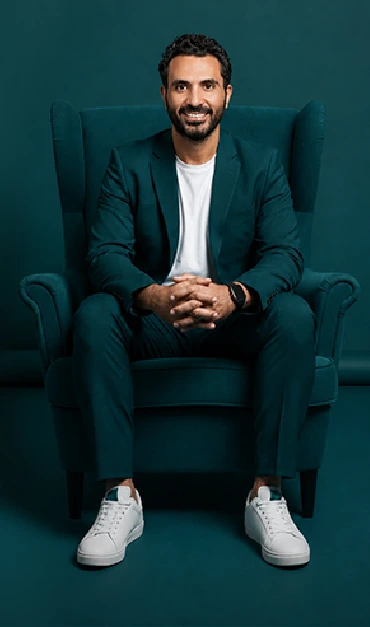 Eslam Shaker seated in a teal armchair